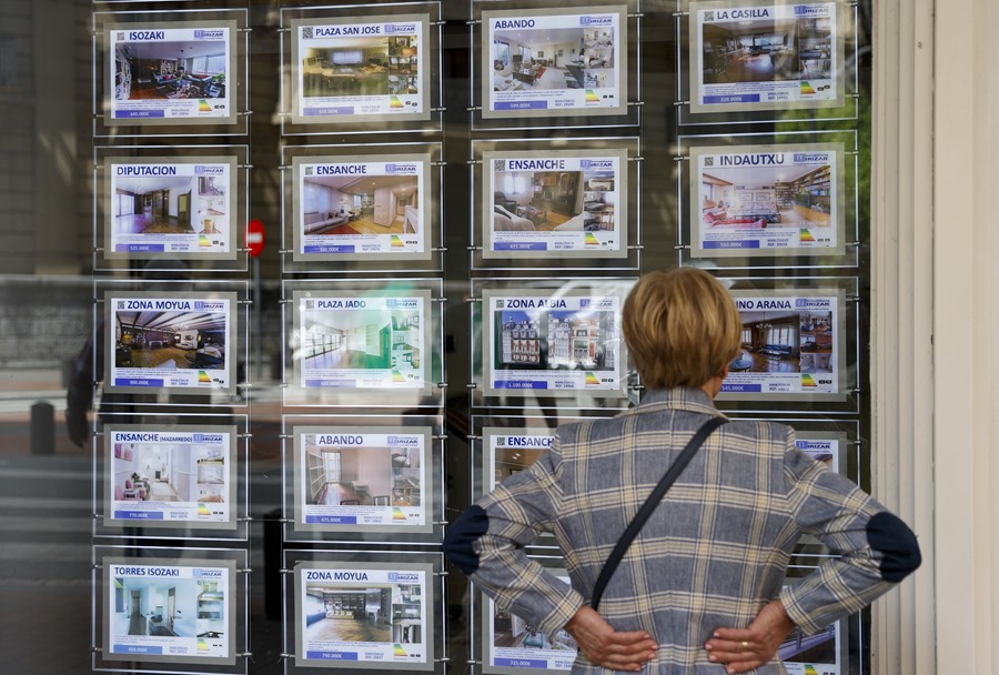 Una mujer mira la oferta de viviendas en una inmobiliaria