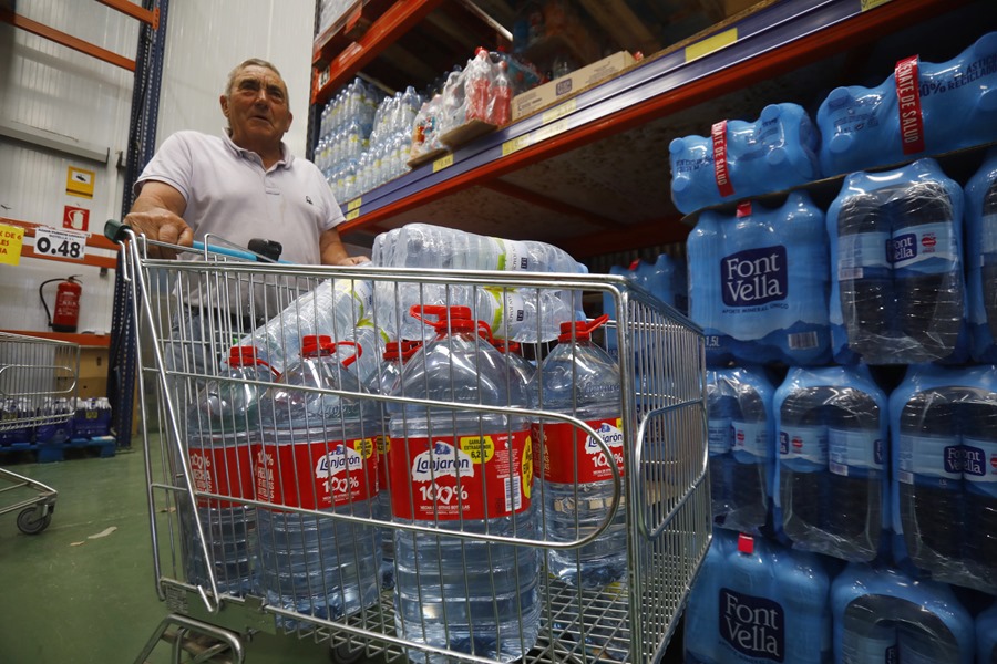 Un vecino de Córdoba compra botellas de agua en un supermercado.