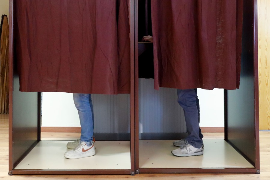 Votantes escogen sus papeletas en un colegio electoral. 