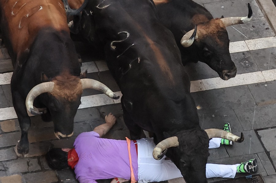 Un mozo caído entre tres toros