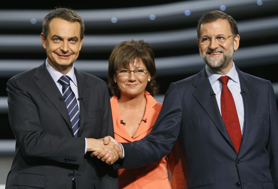 El entonces presidente del Gobierno José Luis Rodríguez Zapatero (i) y el que fuera líder del PP Mariano Rajoy, se saludan en presencia de la periodista Olga Viza, antes del debate cara a cara de 2008. 