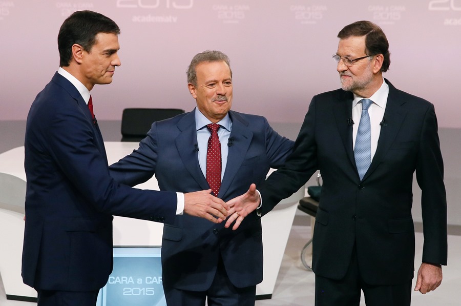 Los entonces candidatos a las elecciones Mariano Rajoy (d) y Pedro Sánchez (i), se saludan en presencia del moderador del debate, Manuel Campo Vida, en 2015.