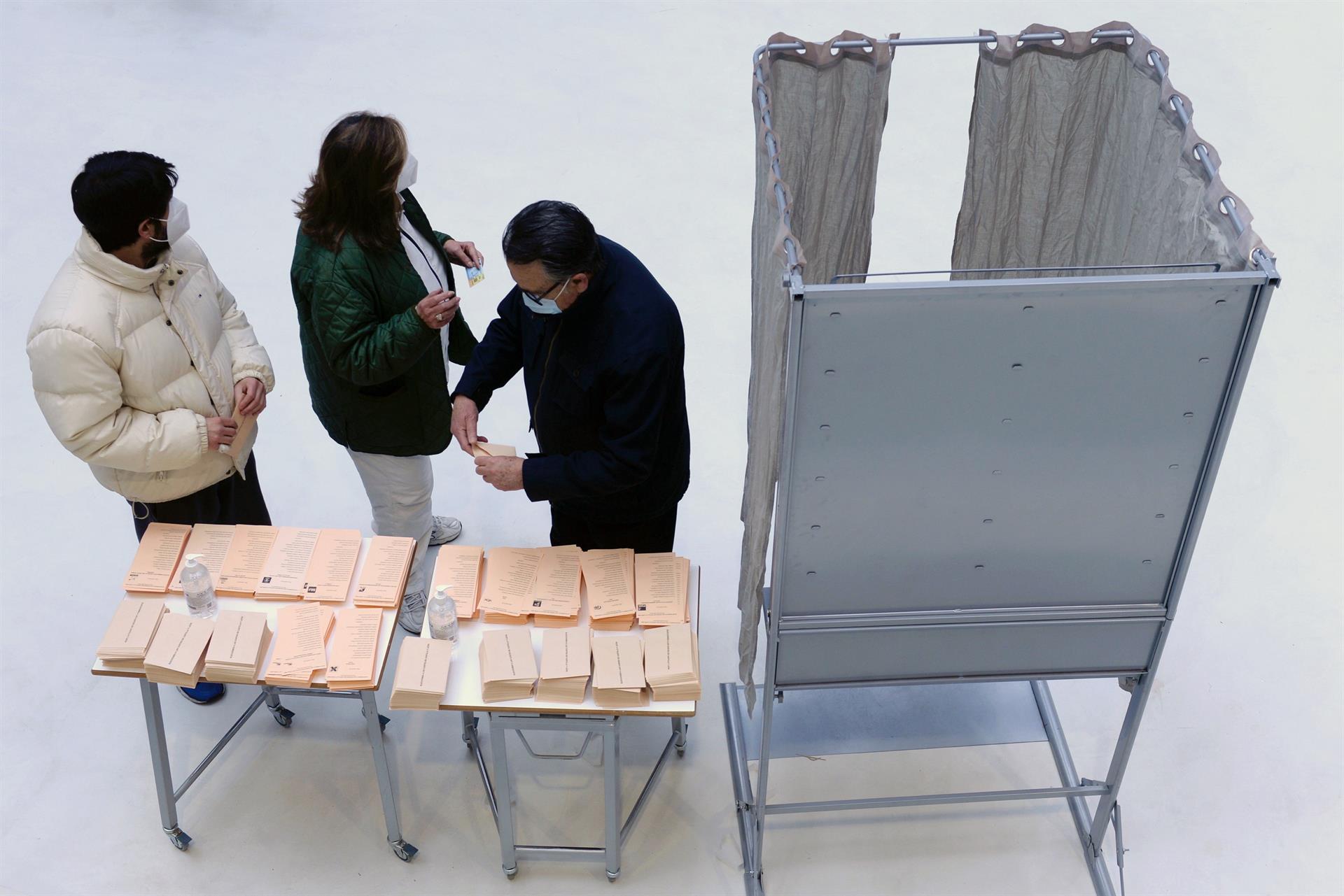Tres personas preparan su voto en un colegio electoral de Valladolid.