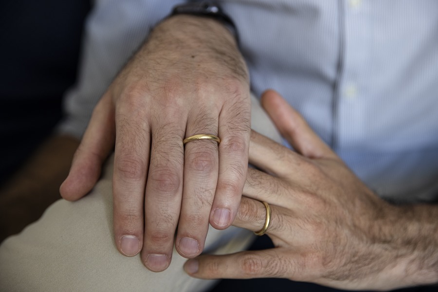 Una pareja muestra sus anillos tras casarse.