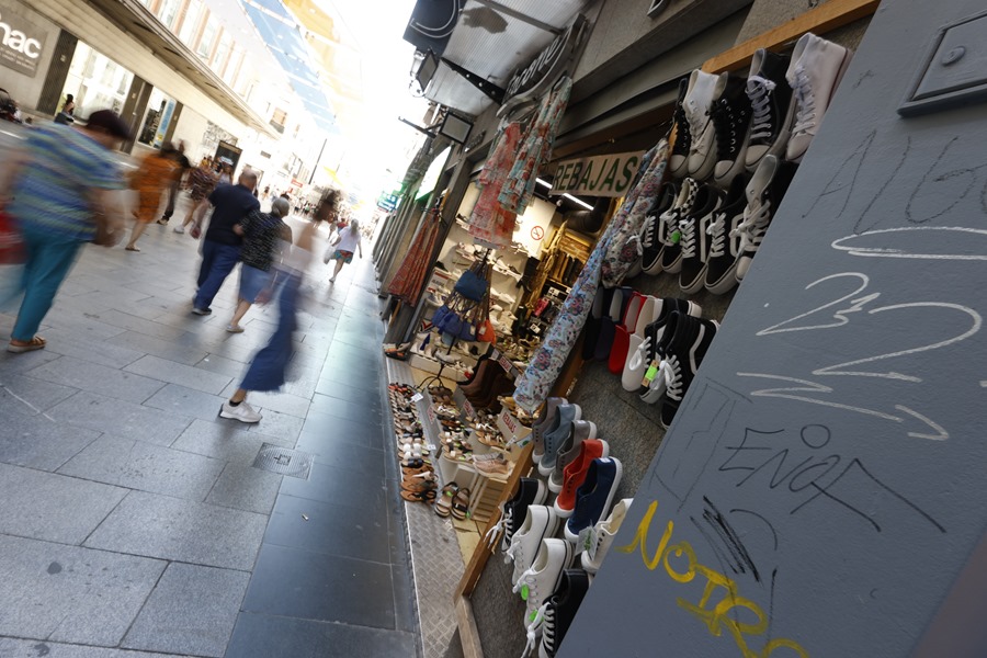 Varias personas observan los escaparates de las tiendas de la calle Preciados de Madrid, este viernes