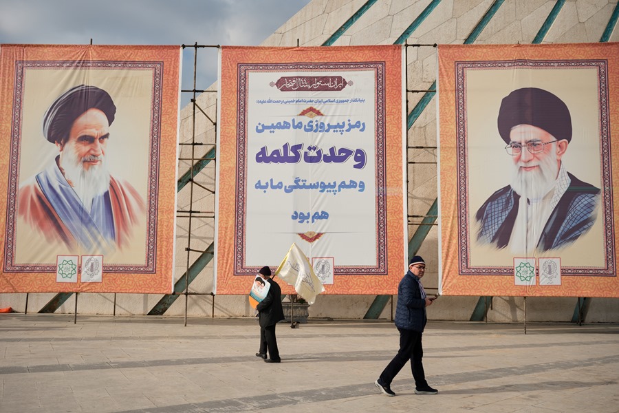 Dos hombres pasan frente a los retratos del líder supremo de Irán, Ali Jameneí, y ayatolá Ruholá Jomeiní , en Teherán.