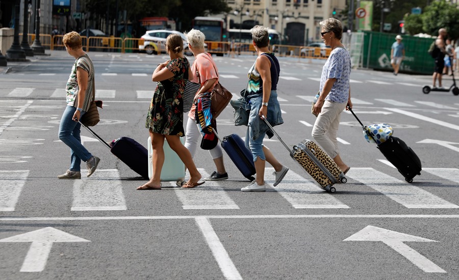 Varias turistas arrastran sus maletas tras abandonar el hotel, en Valencia
