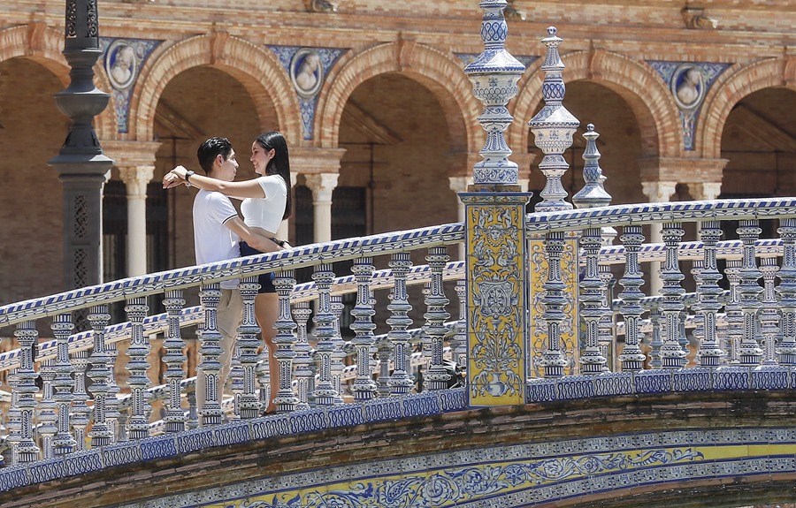 Una pareja recorre la Plaza de España de Sevilla.