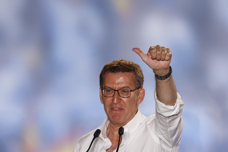 El candidato del Partido Popular, Alberto Núñez Feijoo (i), saluda a los simpatizantes en la sede de los populares en Madrid.