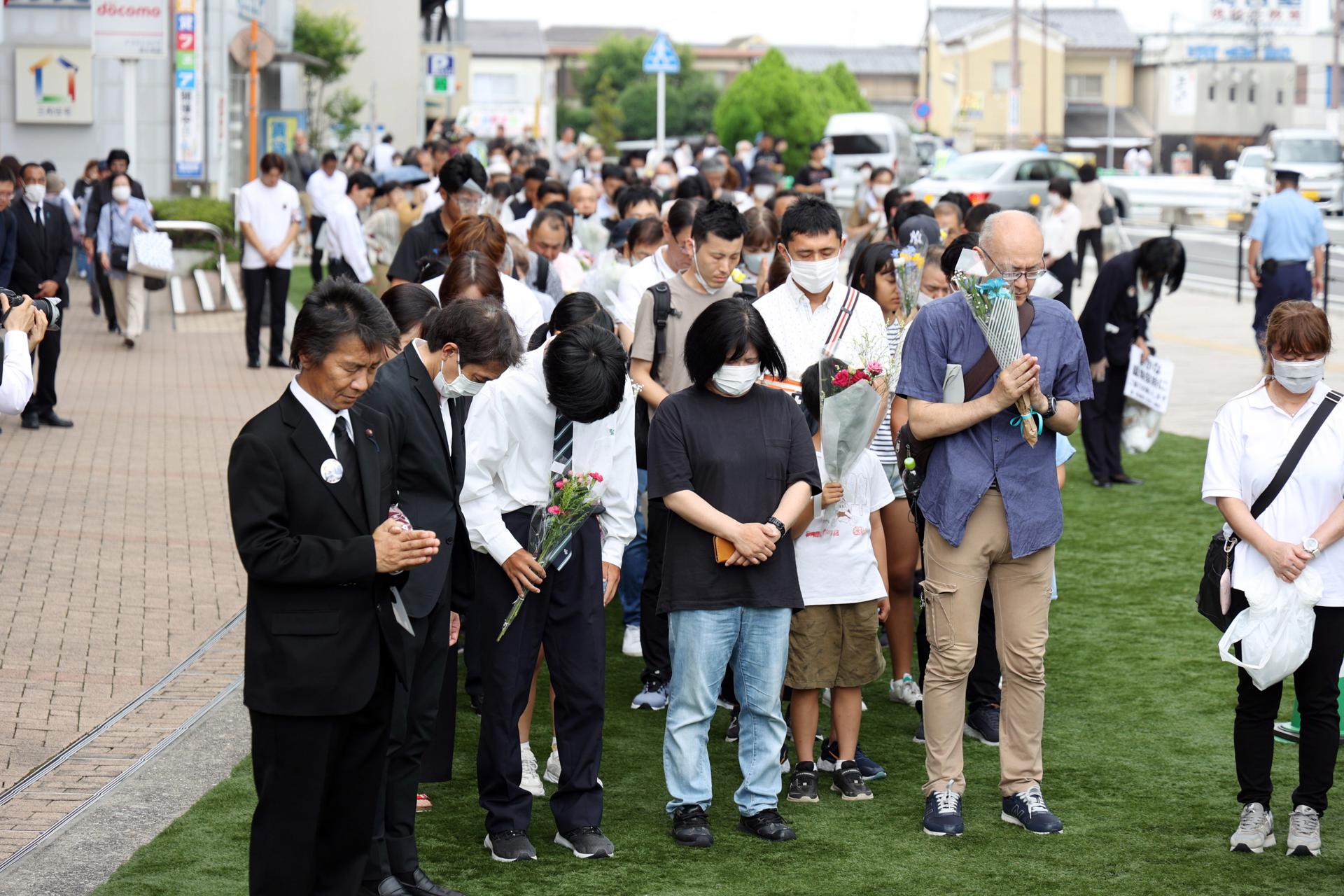 People offer prayers at the time when former Japanese Prime Minister Shinzo Abe was shot a year ago in Nara, western Japan, 08 July 2023.  EFE/EPA/JIJI PRESS JAPAN OUT EDITORIAL USE ONLY