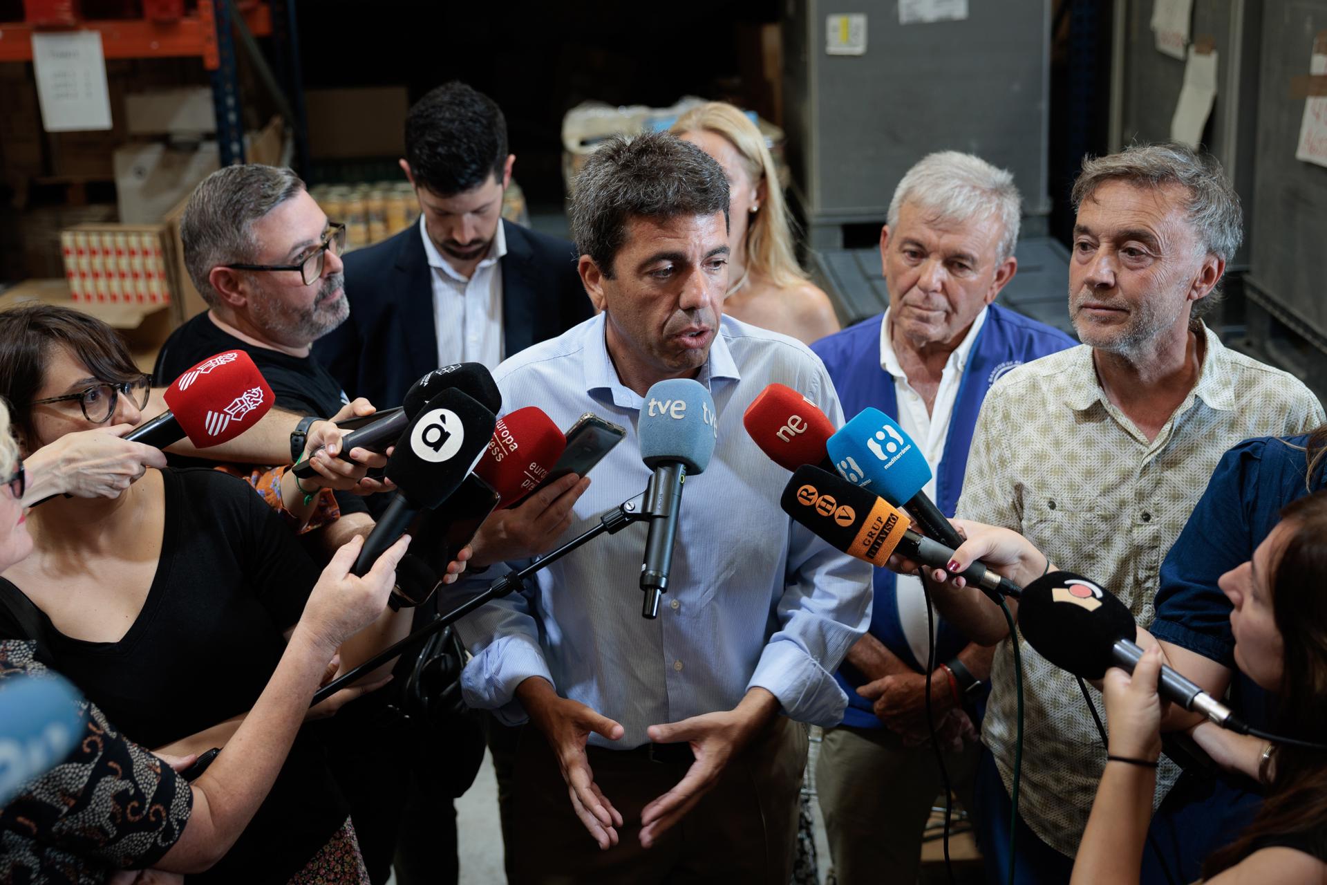 El president de la Generalitat, Carlos Mazón, atiende a los medios durante su visita al Banco de Alimentos de Valencia. EFE/Biel Aliño
