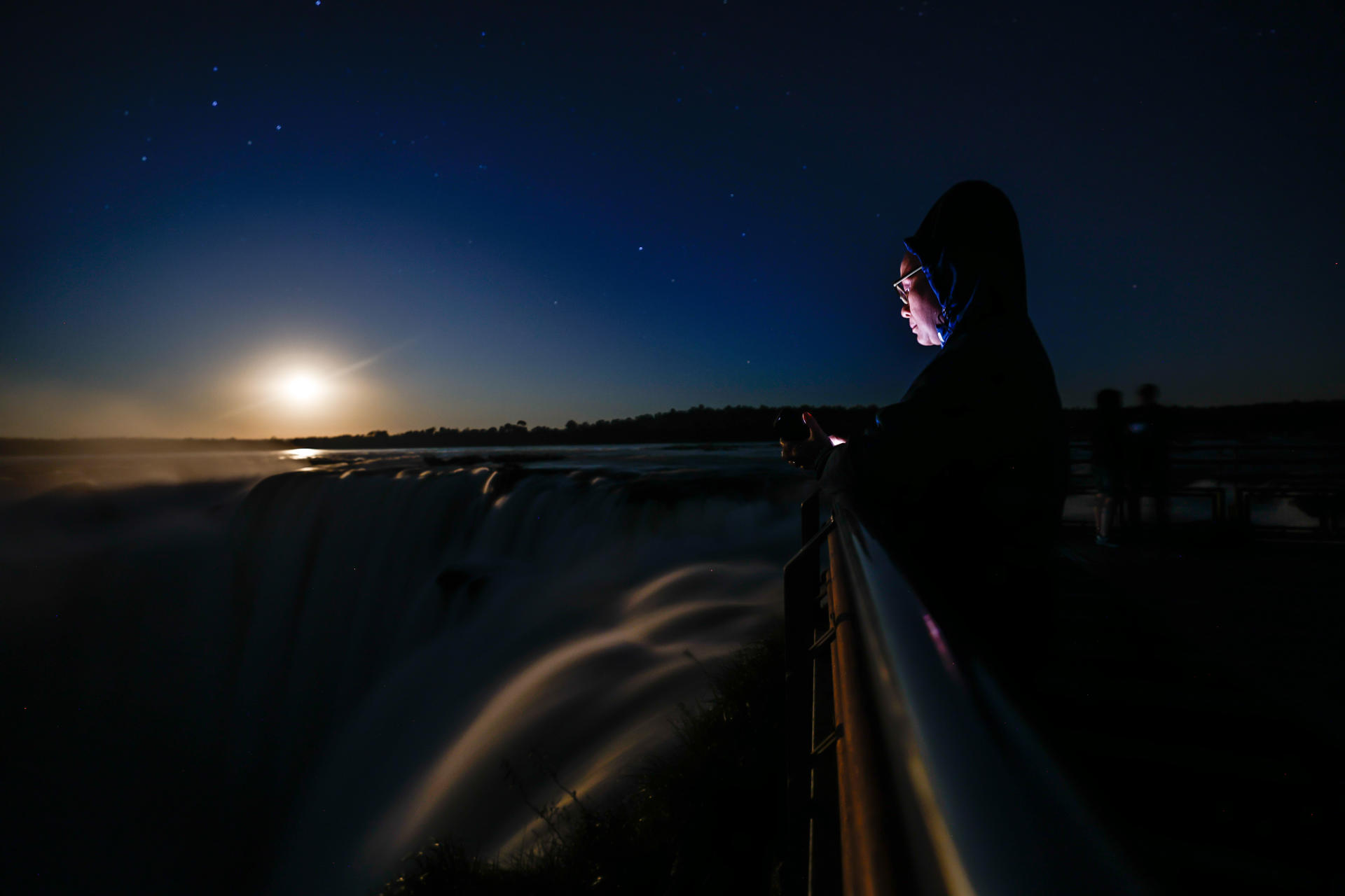 A 4 July 2023 photo of a person checking her cellphone at a lookout point at Iguazu Falls, a UNESCO World Heritage Site located near the town of Puerto Iguazu, Argentina. EFE/ Juan Ignacio Roncoroni
