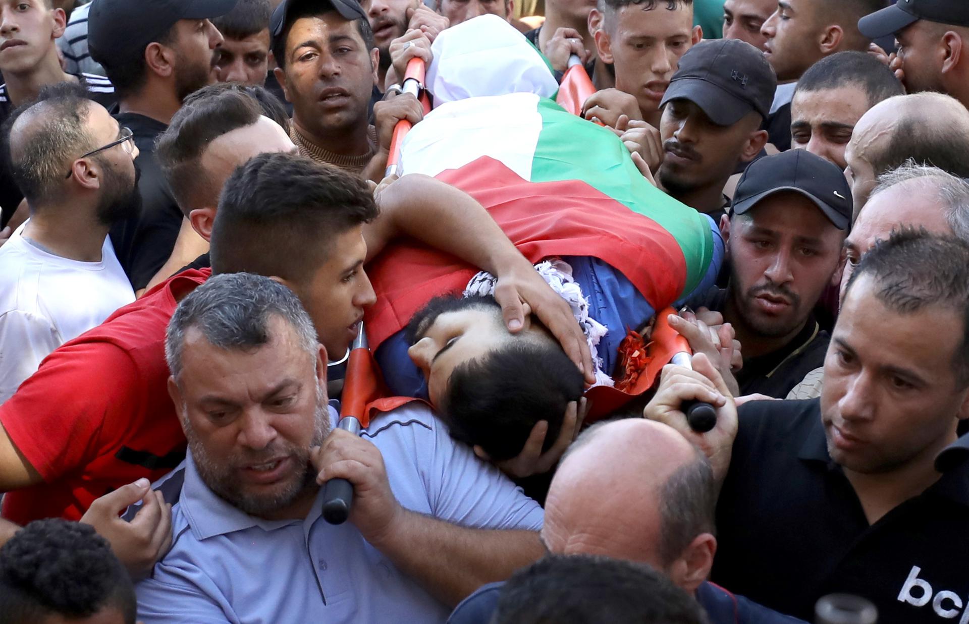 A man touches the body of Mohamed Nada during his funeral after he was killed in an Israeli raid at Al Ein refugee camp near the West Bank city of Nablus, 26 July 2023. EFE-EPA/ALAA BADARNEH