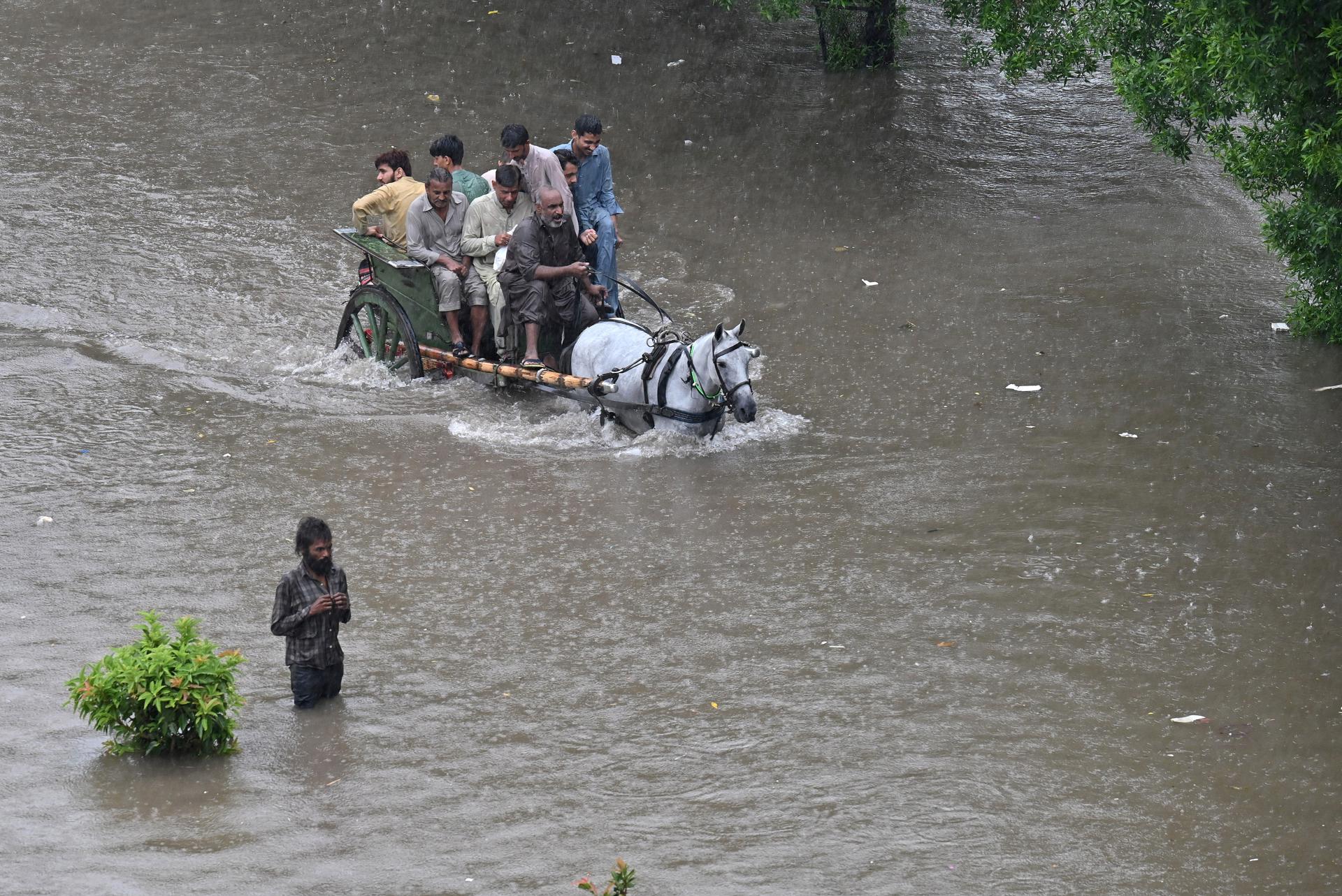 Lahore (Pakistan), 05/07/2023.- People ride a horse-drawn carriage through a flooded area following heavy rains in Lahore, Pakistan, 05 July 2023. Pakistan's Meteorological Department (PMD) has forecast monsoon rains for most parts of Punjab during the next few days, while bursts of heavy rains may cause urban flooding in major cities including Lahore. EFE/EPA/RAHAT DAR
