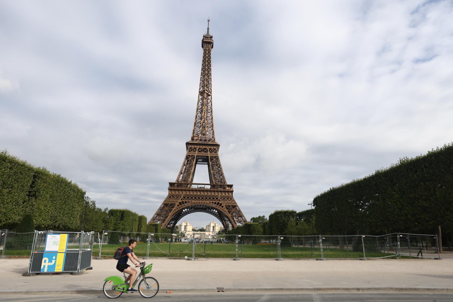 A man rides his bike, passing by Champ de Mars and Eiffel Tower in Paris, France, 03 July 2023. EFE/EPA/MOHAMMED BADRA