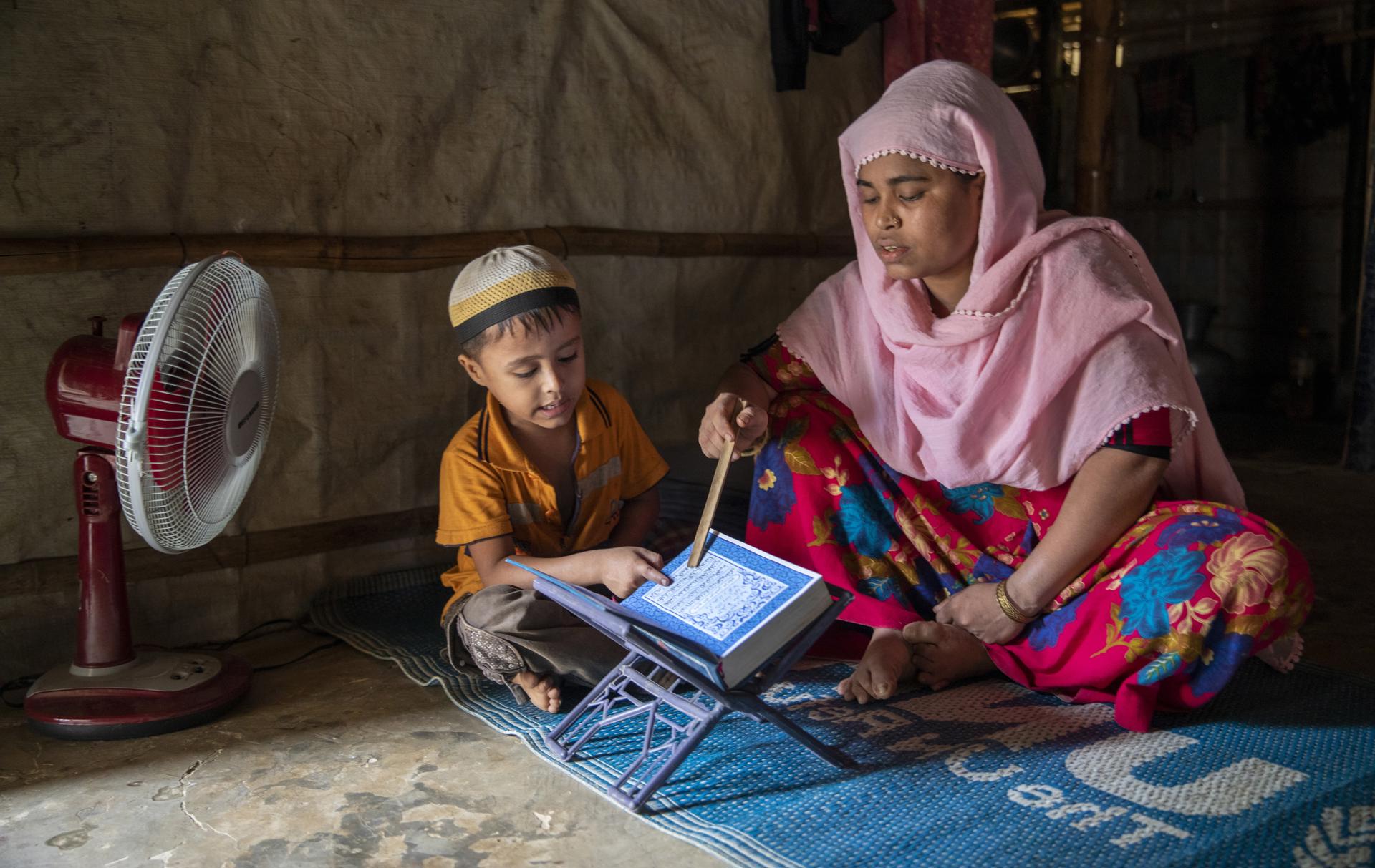 Minara Akhter, 25, a divorced Rohingya refugee, teaches the holy Quran Sharif to her son Mohammad Abdullah, 7, at a makeshift camp in Kutupalong, Ukhiya Cox's Bazar, Bangladesh, 14 June 2023 (issued 19 June 2023). EFE-EPA FILE/MONIRUL ALAM ATTENTION: This Image is part of a PHOTO SET