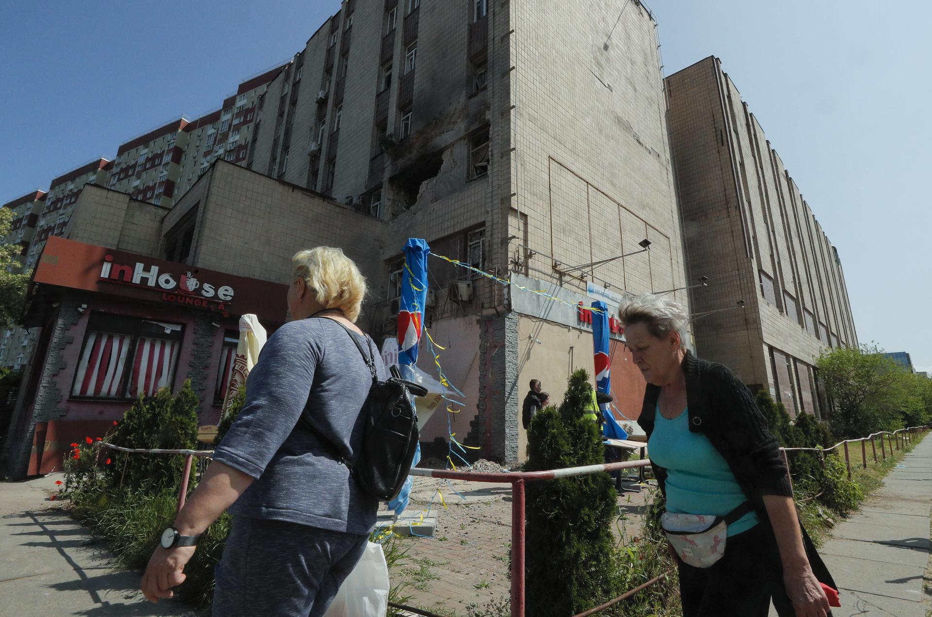 (FILE) People walk by a damaged administrative building after an overnight shelling by shock drones in Kyiv, Ukraine, 28 May 2023 amid the Russian invasion. EFE/EPA/SERGEY DOLZHENKO