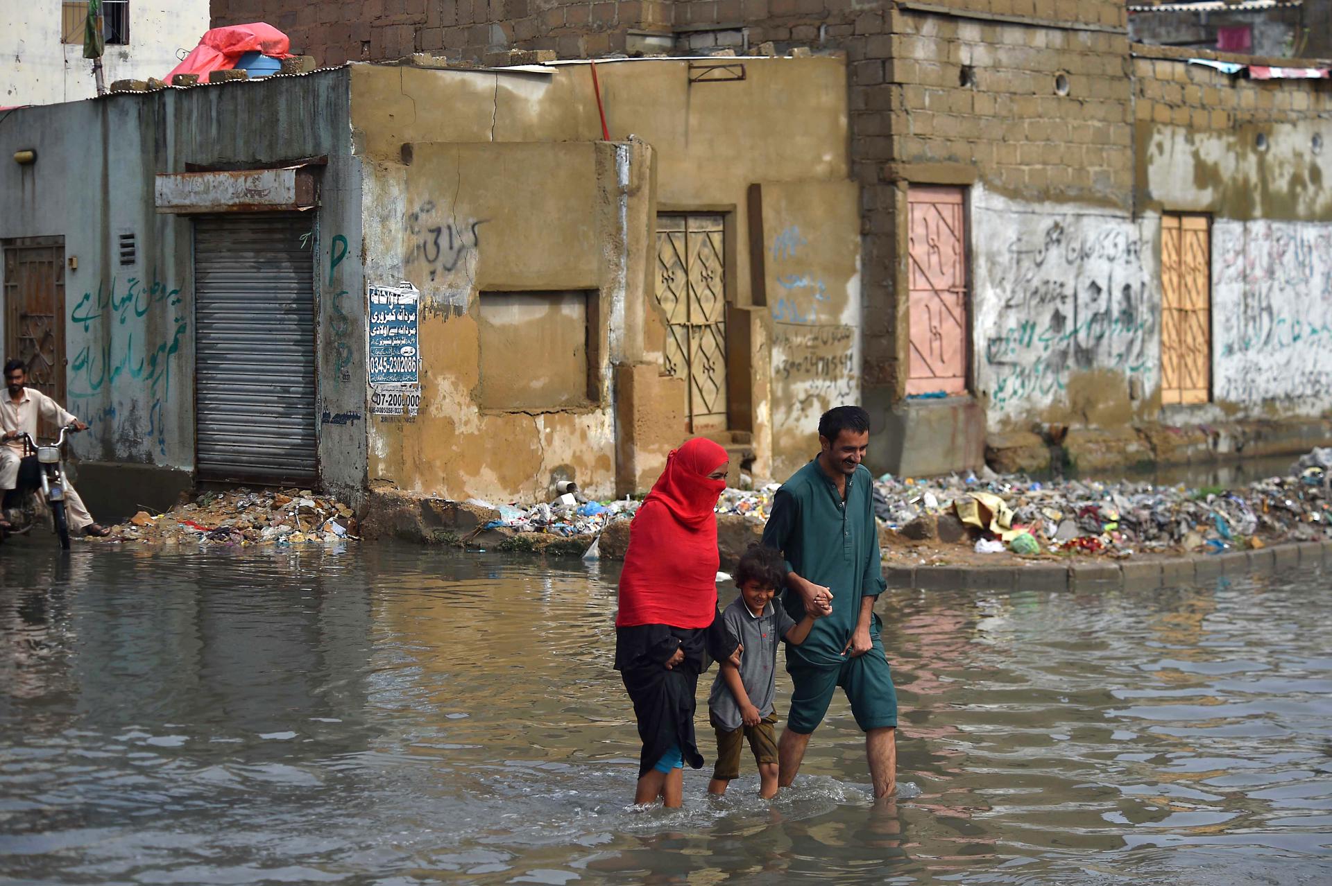 People make their way through a flooded road following heavy monsoon rains in Karachi, Pakistan, 25 July 2023. EFE-EPA FILE/SHAHZAIB AKBER