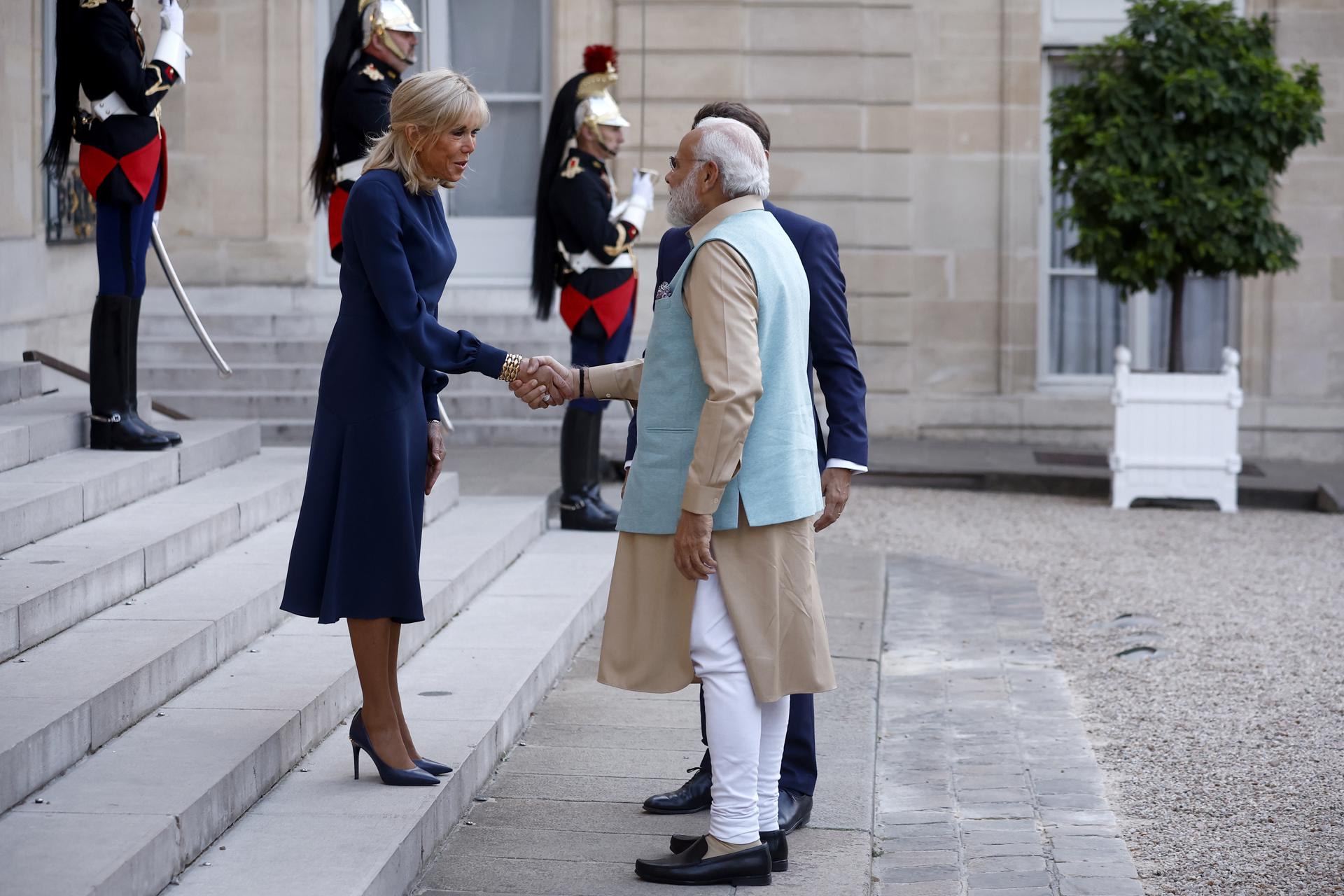 French President Emmanuel Macron (back, partly seen) and French First Lady Brigitte (L) Macron greet India's Prime Minister Narendra Modi (C) upon his arrival at the Elysee Palace in Paris, France, 13 July 2023. EFE-EPA/YOAN VALAT
