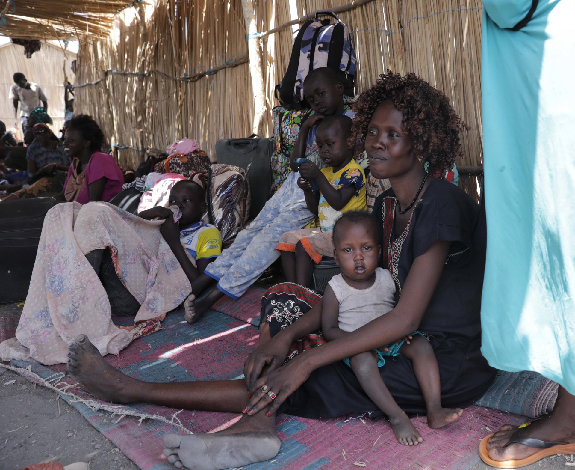 A South Sudanese returnee who fled Sudan with her children takes rest and shelters from the heat while waiting to move toward the town of Renk, at Wunthaou near the border with Sudan, South Sudan, 12 May 2023. EFE-EPA/AMEL PAIN