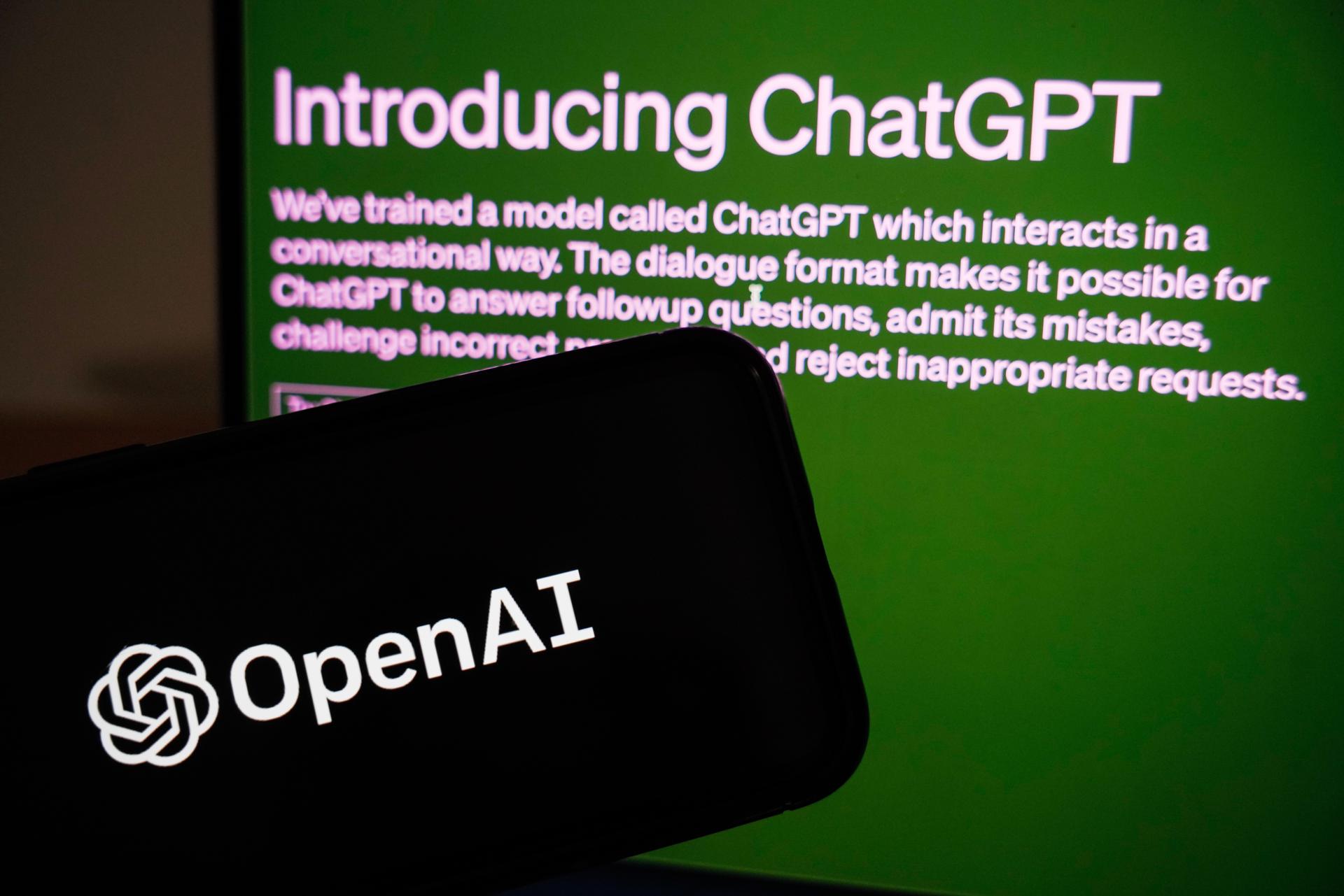 Vista del logo de la empresa OpenAI junto a un monitor en el que se ve el ingreso a ChatGPT, en una fotografía de archivo. EFE/Wu Hao