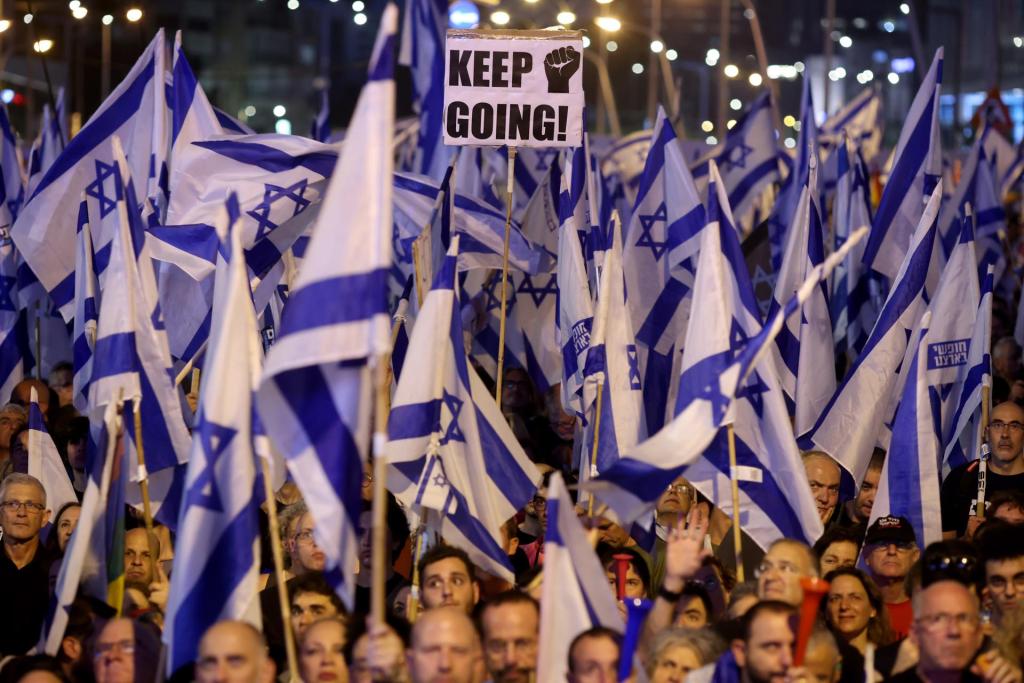 Los manifestantes ondean banderas durante una protesta contra el Gobierno del primer ministro israelí, Benjamín Netanyahu, y su coalición nacionalista por sus planes de reforma del sistema judicial, en Tel Aviv.