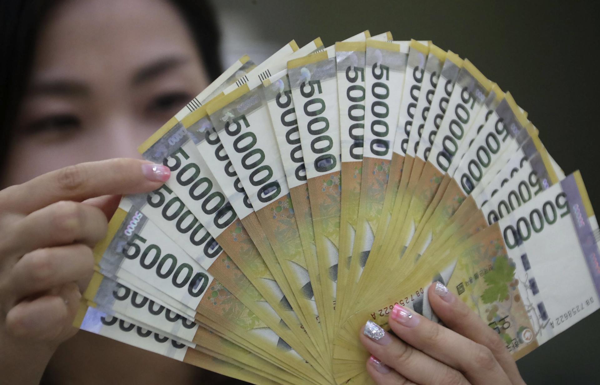 A bank employee shows several 50,000 won notes in Seoul, South Korea, on 7 August, 2017. EFE-EPA FILE/YONHAP/USE OF THIS IMAGE IS PROHIBITED IN SOUTH KOREA