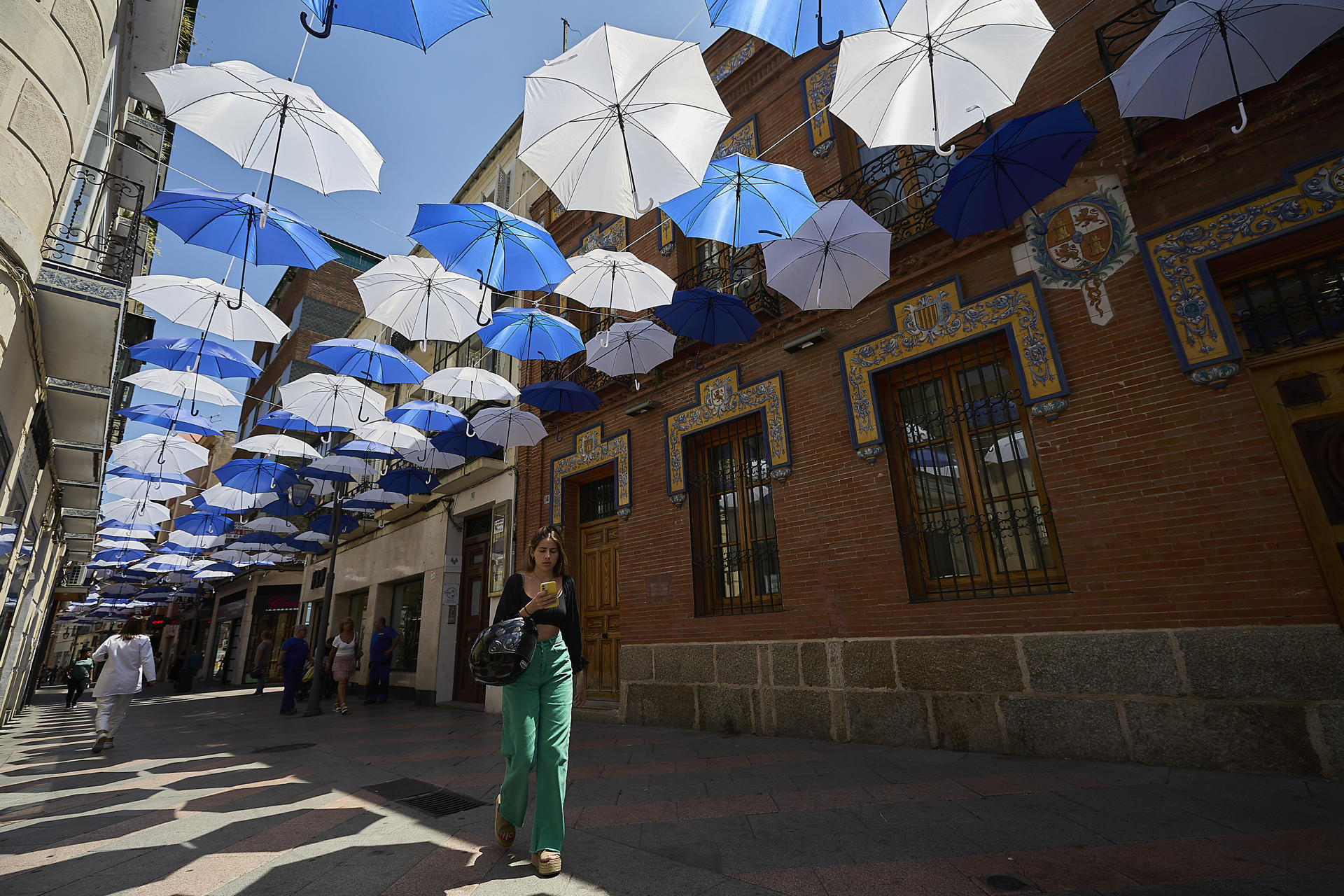 El Ayuntamiento de Talavera de la Reina (Toledo) ha avanzado que instala en la calle San Francisco, una de las principales vías comerciales del centro, 500 paraguas con el objetivo de que la ciudadanía se pueda resguardar del calor. EFE/Manu Reino