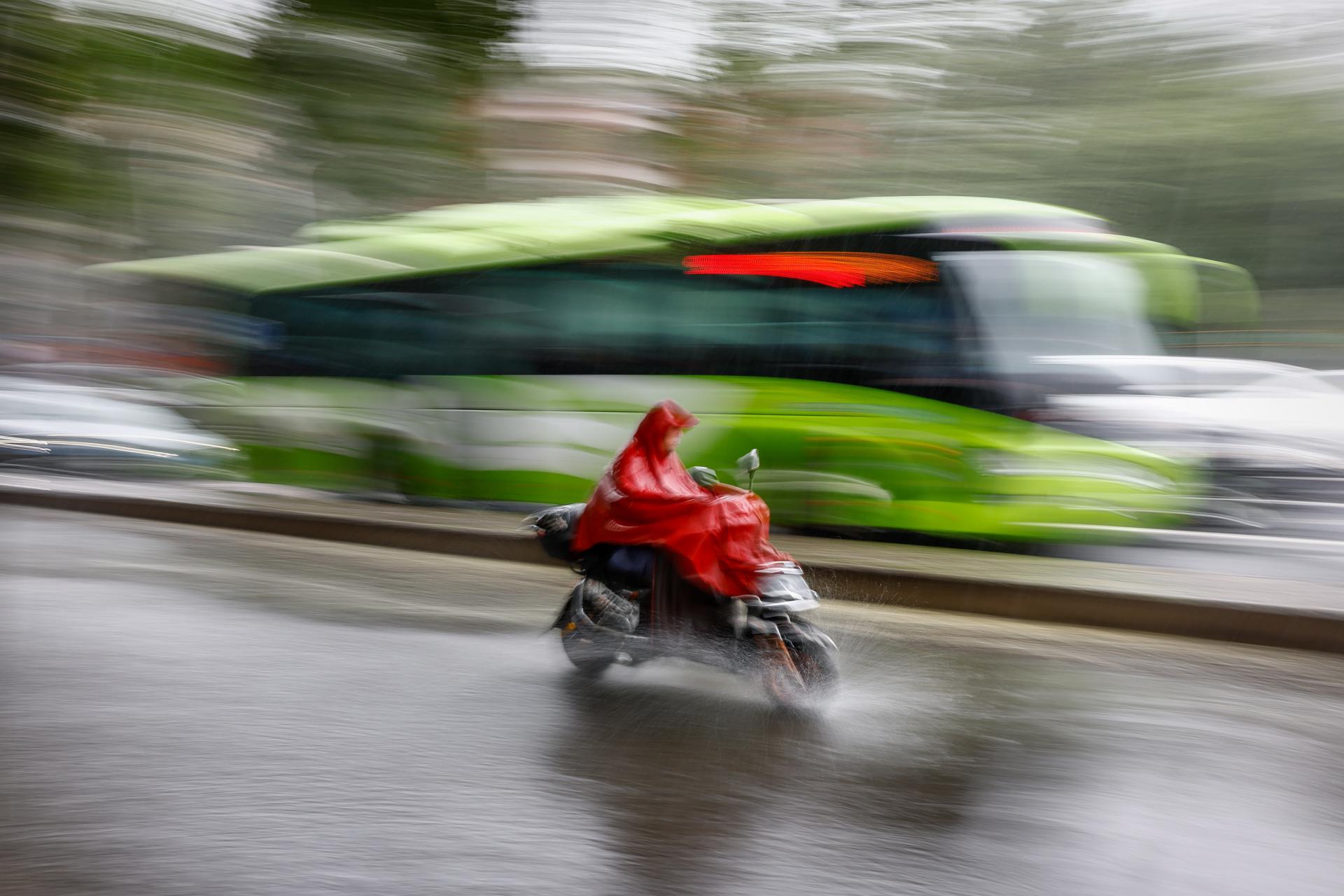 A man rides an electric scooter during a downpour in Beijing, China, 30 July 2023. EFE-EPA/MARK R. CRISTINO
