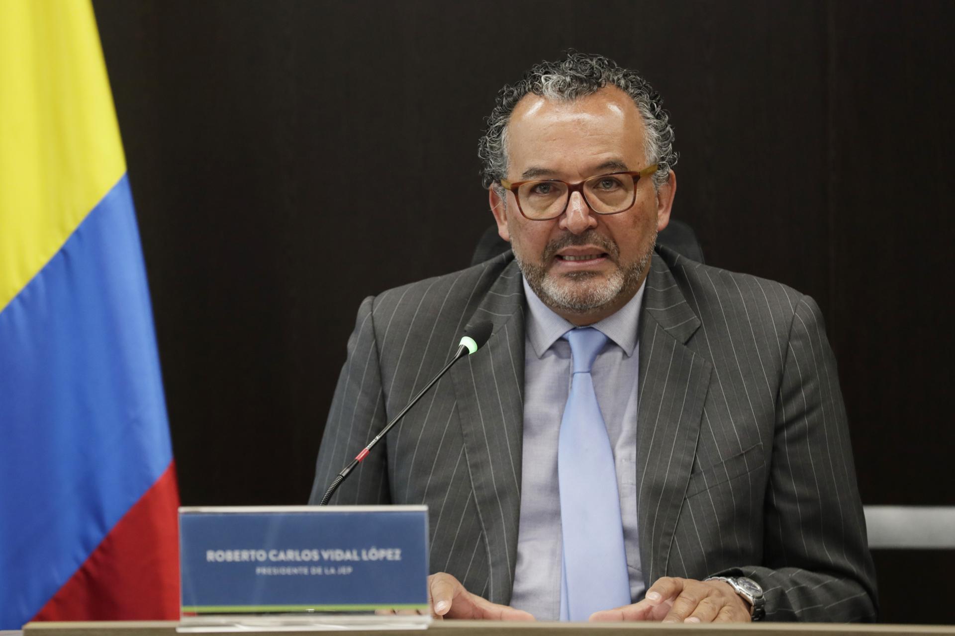 The chief justice of Colombia's Special Jurisdiction for Peace (JEP), Roberto Carlos Vidal (left), speaks during a press conference on 7 July 2023 in Bogota, Colombia, after war-crimes charges were announced against 10 ex-FARC mid-level commanders. EFE/Carlos Ortega
