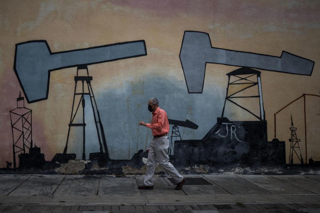 Un hombre camina frente a un mural en el Complejo MinPetróleo - Petróleos de Venezuela S.A. (Pdvsa), el 27 de julio de 2023 en Caracas (Venezuela). EFE/Miguel Gutiérrez
