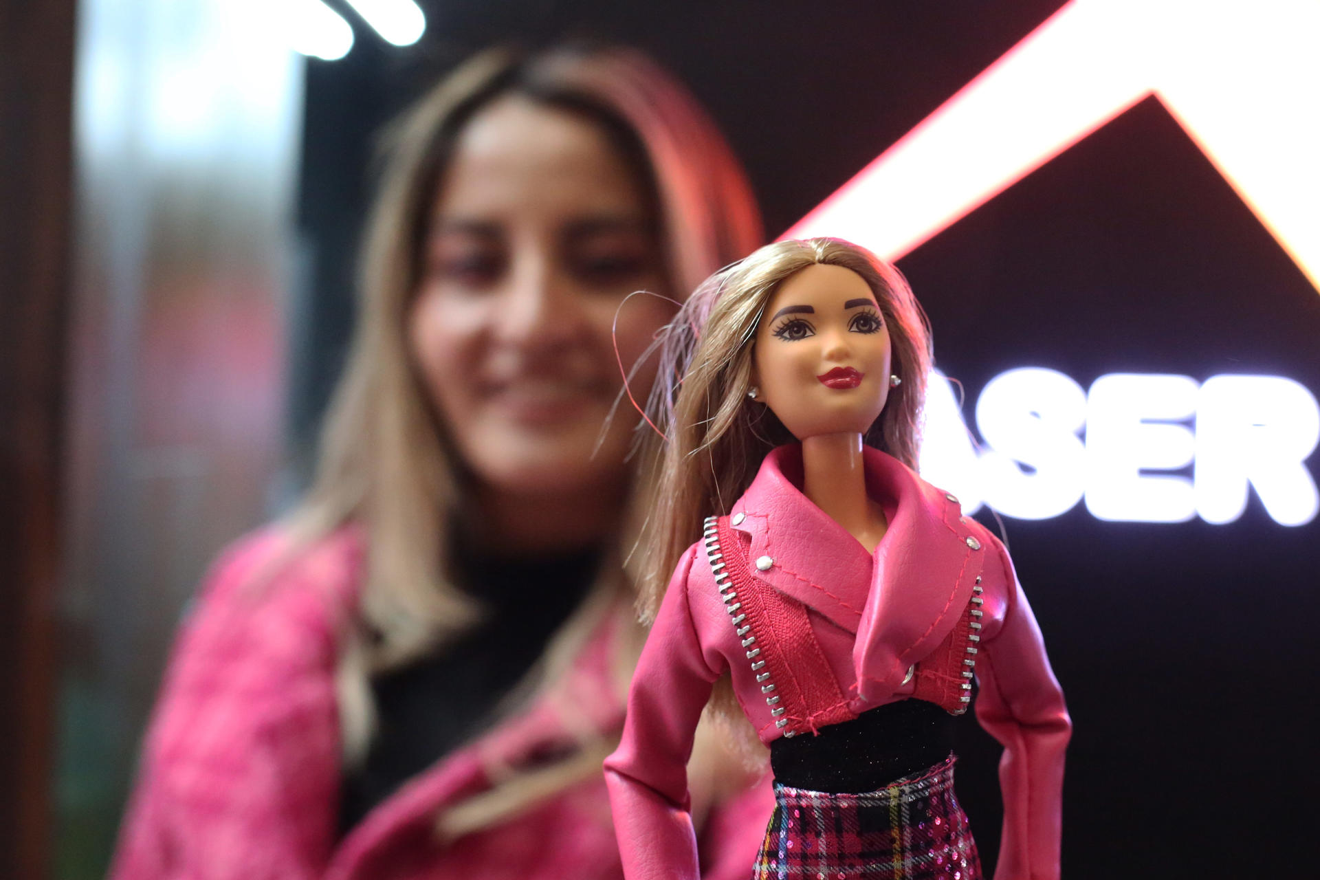 A young woman attends the premiere of the movie Barbie with a doll in La Paz, Bolivia on 20 July 2023. EFE-EPA/Luis Gandarillas
