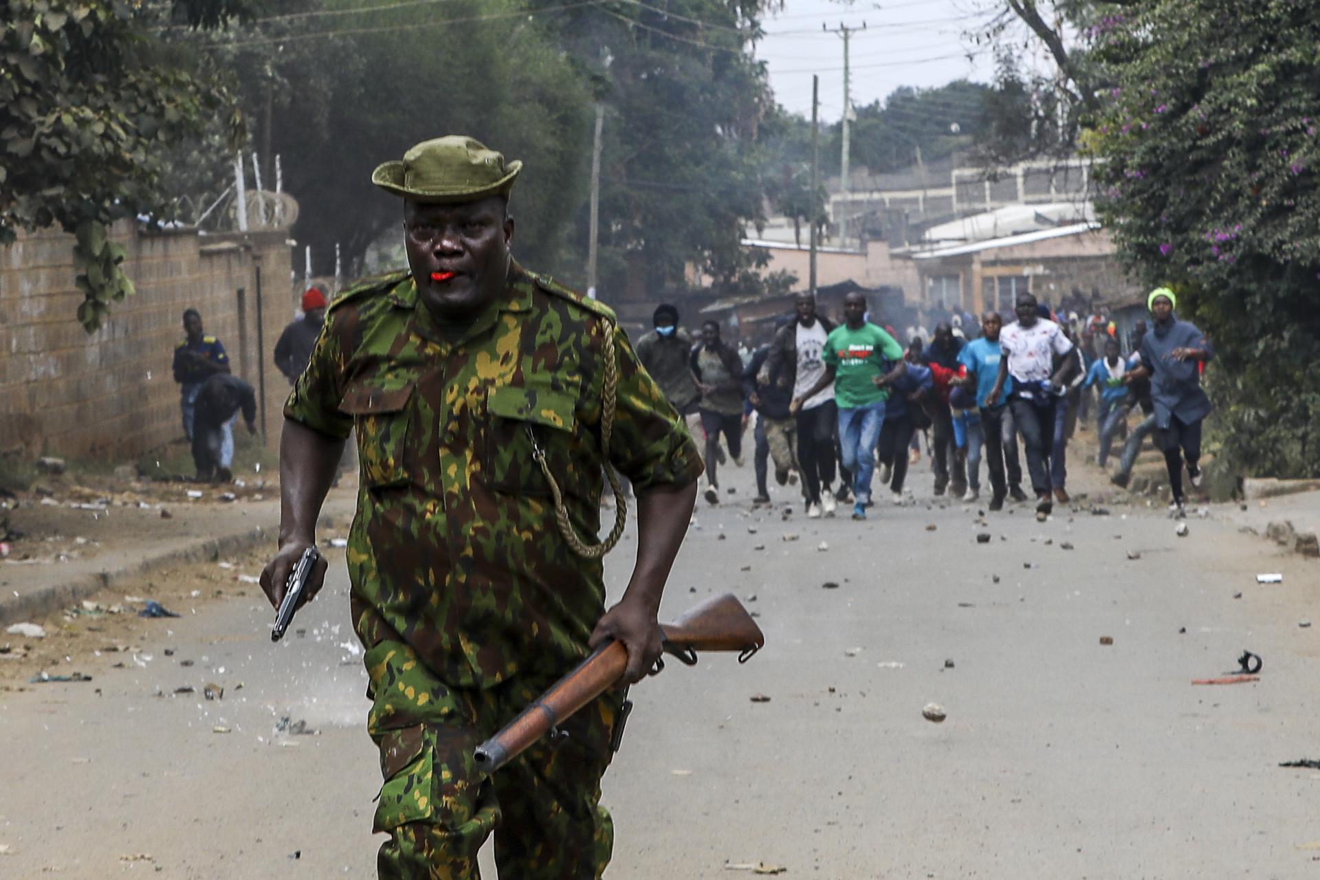 An armed anti-riot police officer (C) runs away from a group of angry protestors and supporters of the opposition Azimio coalition as they throw stones towards the police, during new nationwide protests, in Nairobi, Kenya, 19 July 2023. EFE/EPA/Daniel Irungu
