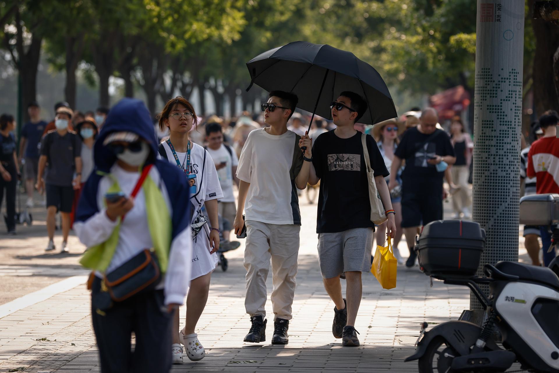 People walk along a road in Beijing, China, 17 June 2023. EFE/EPA/FILE/MARK R. CRISTINO