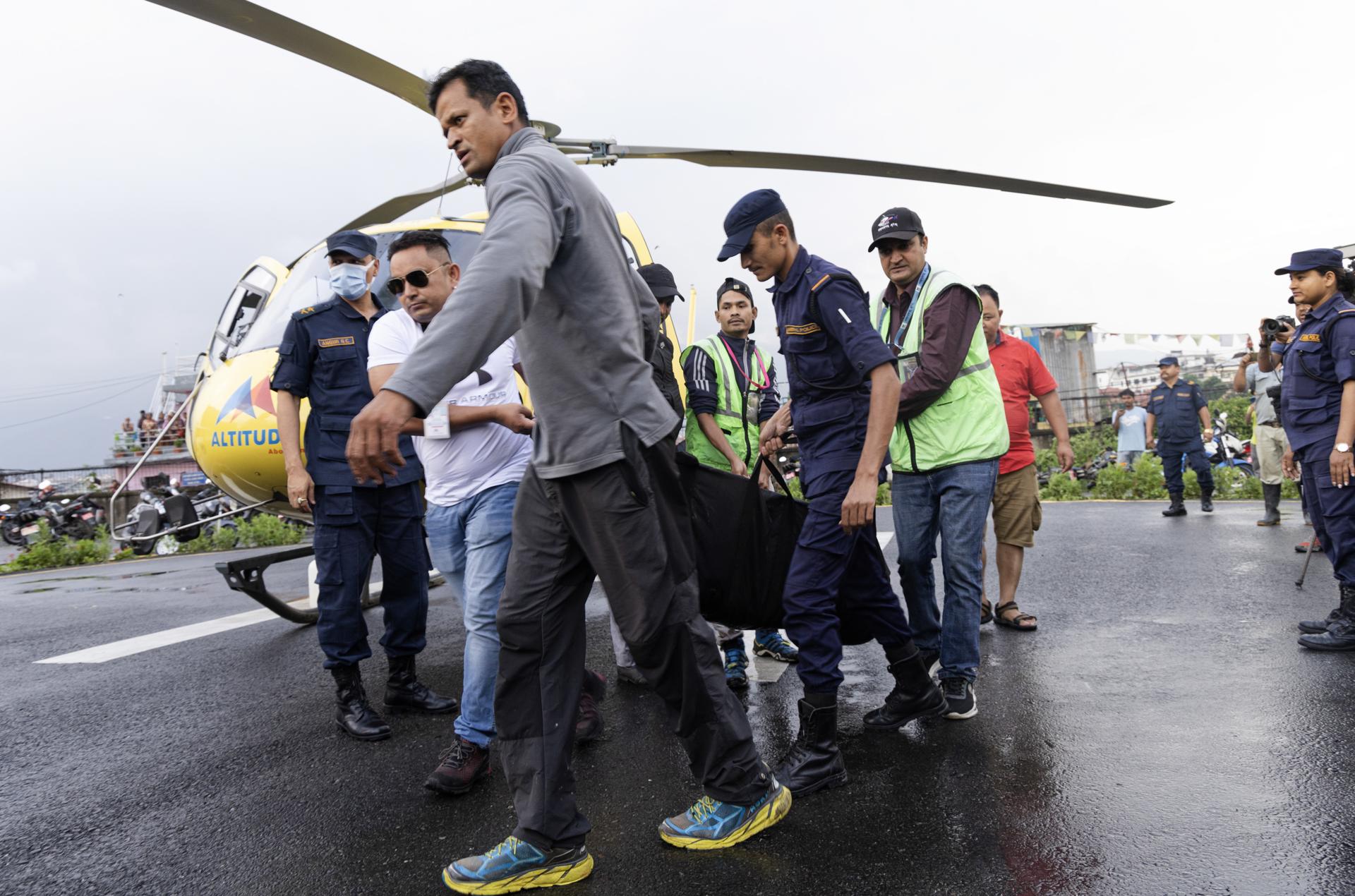 Nepalese airlines staff and policemen carry the bodies of the victims, following the crash of a Manang Air helicopter, at the helipad of Teaching Hospital in Kathmandu, Nepal, 11 July 2023. EFE/EPA/NARENDRA SHRESTHA
