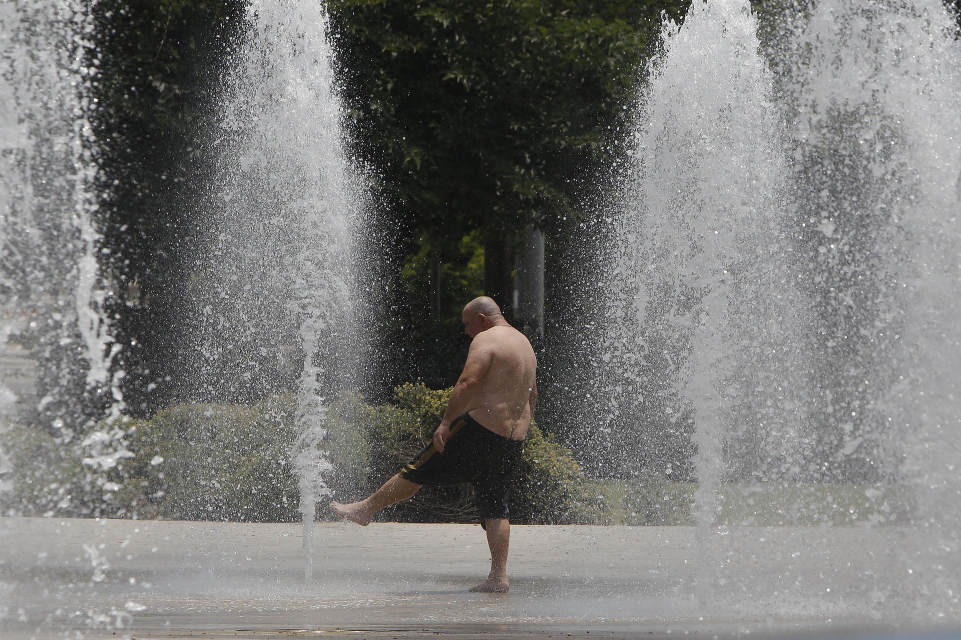 En la imagen, una persona se refresca en una fuente pública de Alicante. EFE/ Morell
