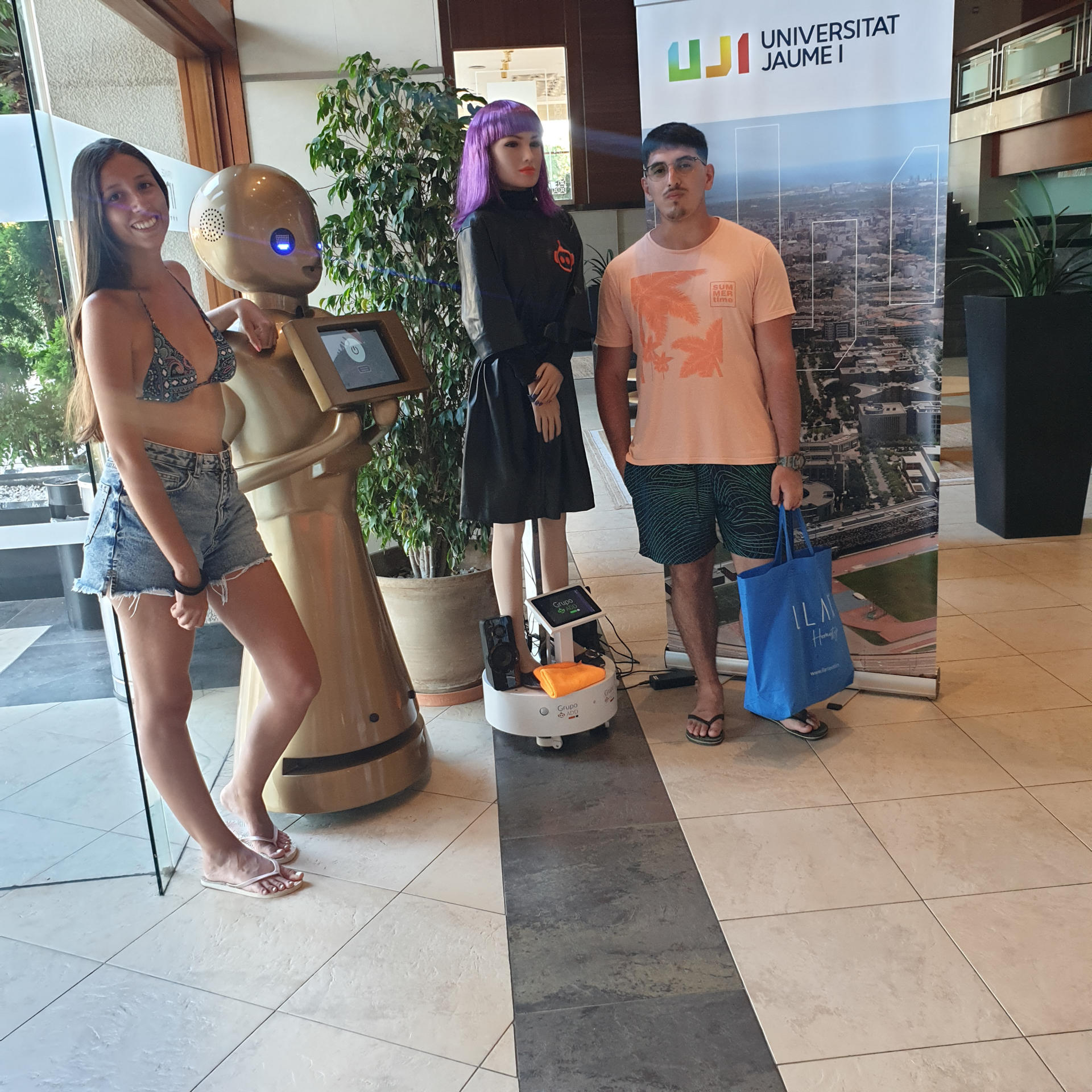 Imagen de los robots junto a dos jóvenes facilitada por la universidad.