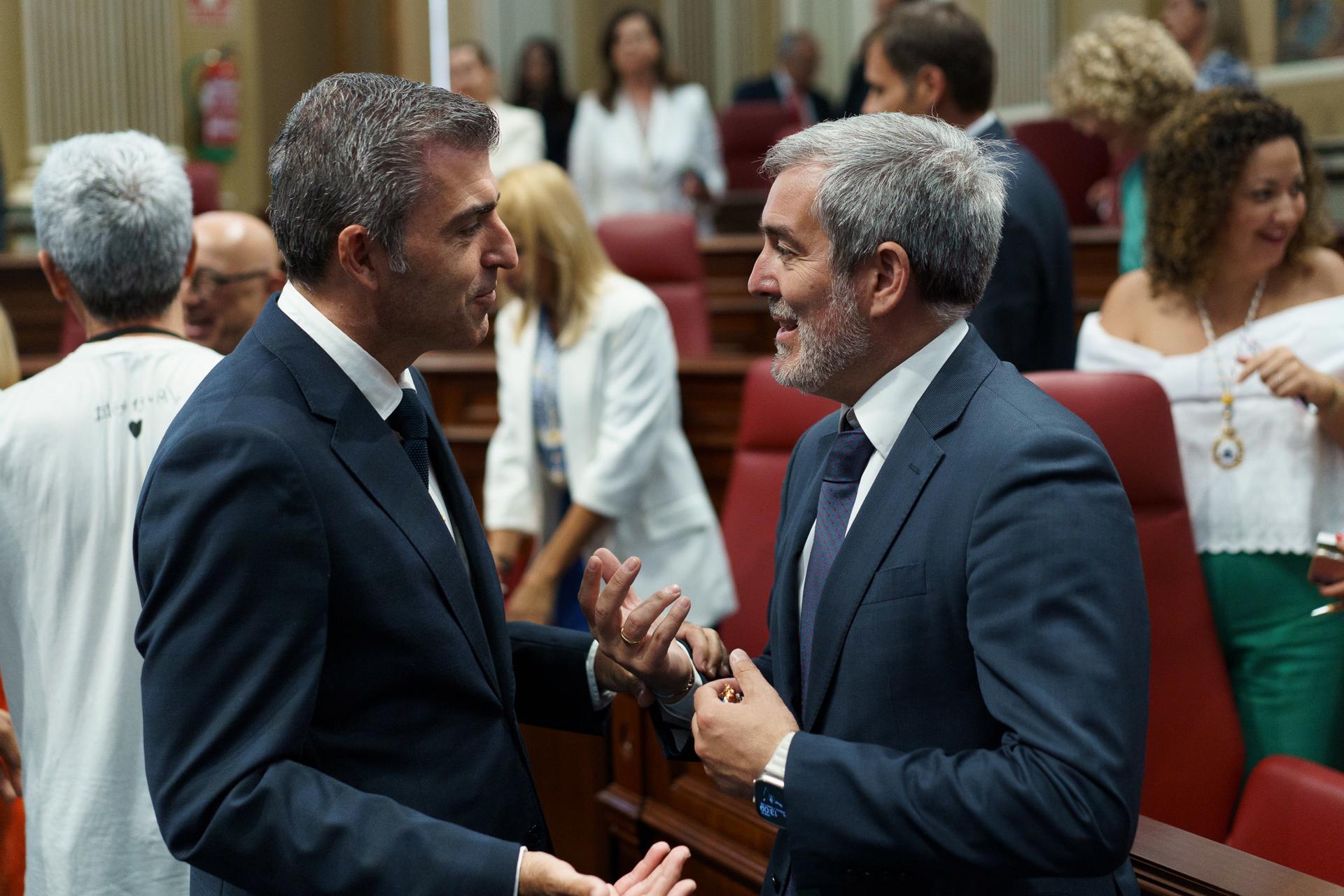 El presidente de Canarias, Fernando Clavijo (d), conversa con el líder del PP y futuro vicepresidente de su Ejecutivo, Manuel Domínguez (i) durante el debate de investidura del primero en el Parlamento. EFE/Ramón de la Rocha