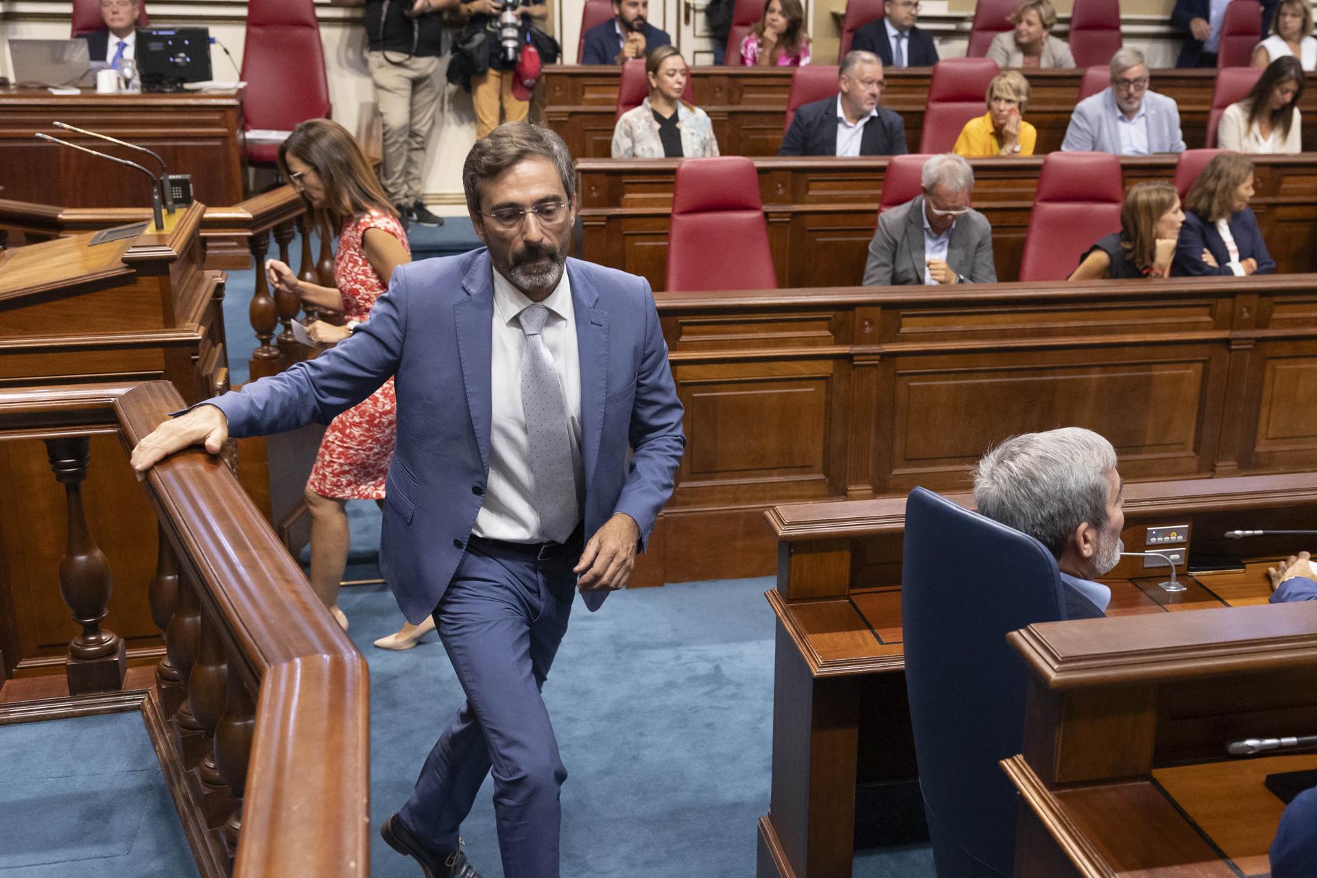 El nuevo senador autonómico por CC, Pedro San Ginés (c), pasa tras el escaño del presidente de Canarias, Fernando Clavijo (d), durante el pleno del Parlamento autonómico. EFE/ Miguel Barreto
