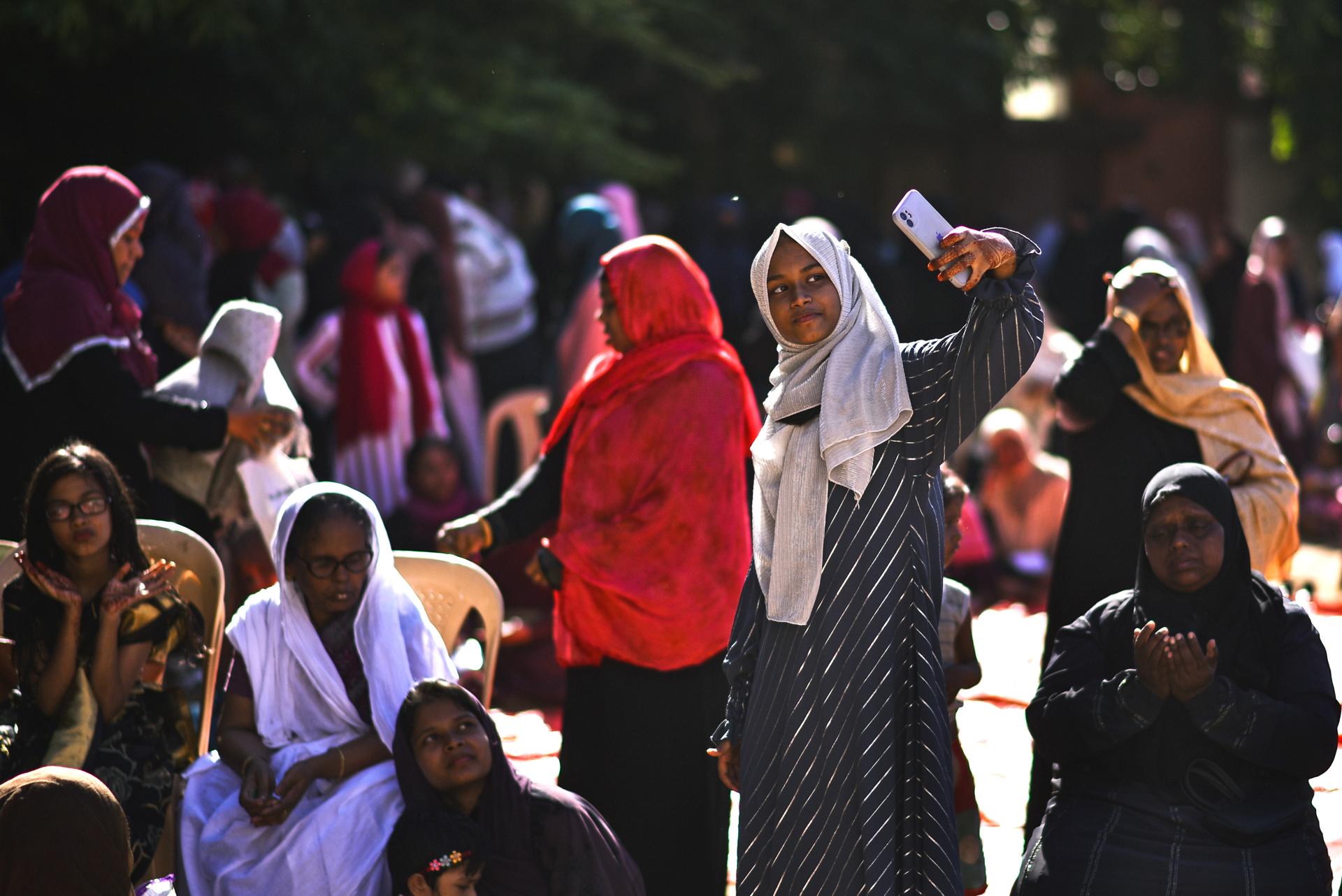 A Muslim woman takes a selfie after offering prayers on the occasion of the Eid al-Adha, at a school ground, in Chennai, India, 29 June 2023. EFE-EPA FILE/IDREES MOHAMMED
