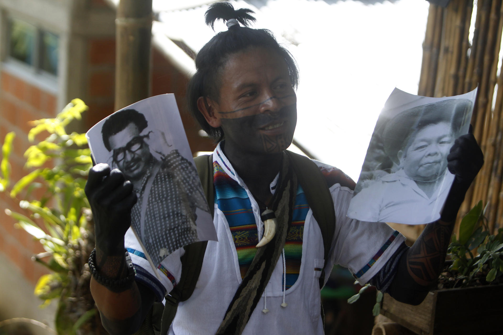 James Tascon, a member of the Embera Chami indigenous group, shows photos of community leaders to people visiting the Karmata Rua indigenous reserve in northwestern Colombia. EFE/ Luis Eduardo Noriega A.
