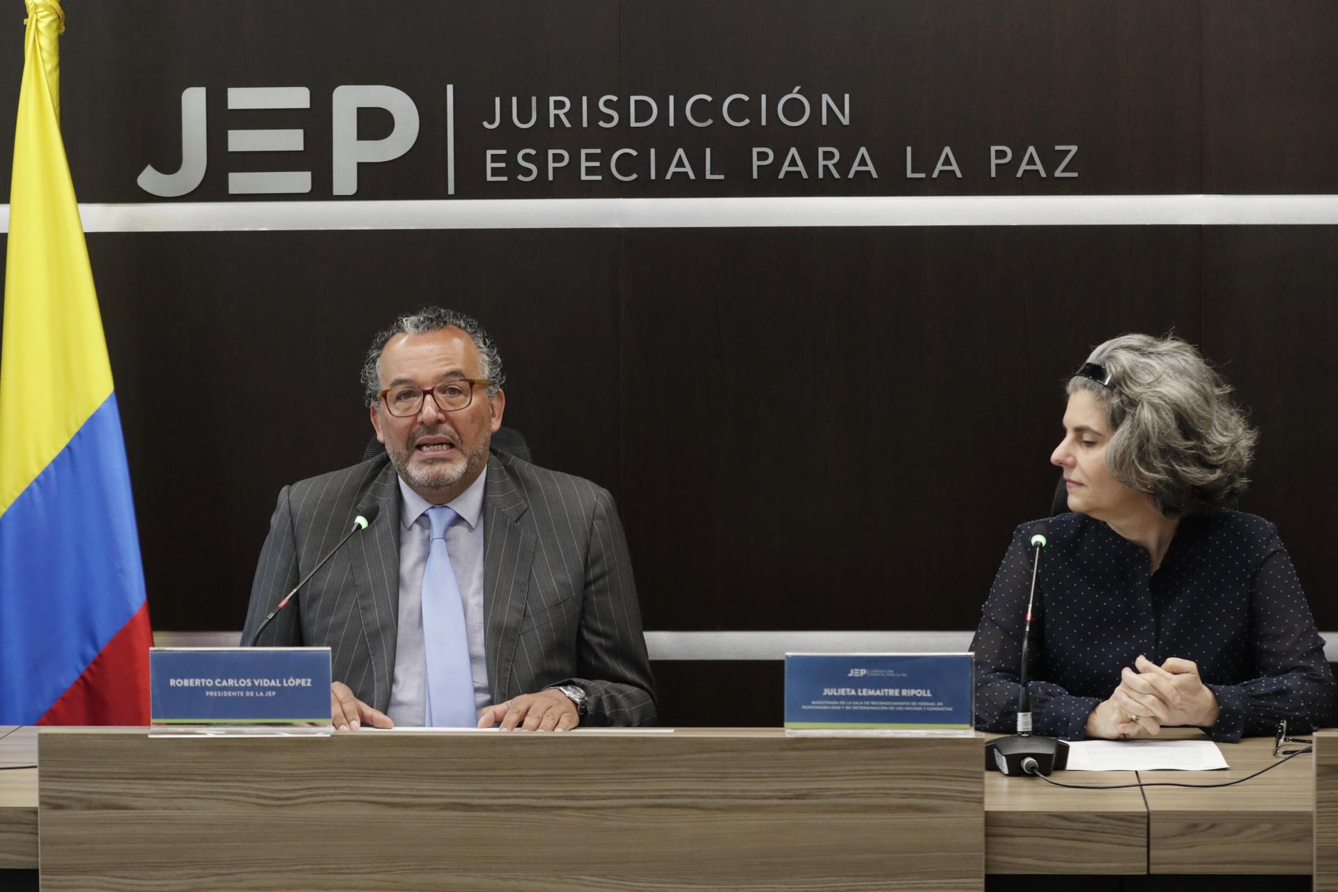 The chief justice of Colombia's Special Jurisdiction for Peace (JEP), Roberto Carlos Vidal (left), speaks alongside Judge Julieta Lemaitre during a press conference on 7 July 2023 in Bogota, Colombia, after war-crimes charges were announced against 10 ex-FARC mid-level commanders. EFE/Carlos Ortega