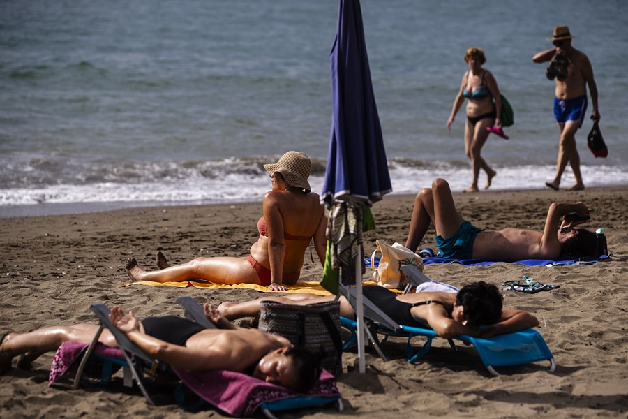 Varias personas toman el sol en la playa de la Misericordia en Málaga, este sábado, durante la jornada de reflexión