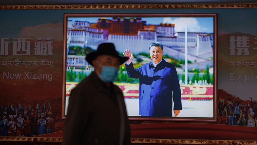 Un hombre pasa junto a una imagen del presidente de China, Xi Jinping, en Lhasa, Tíbet. 