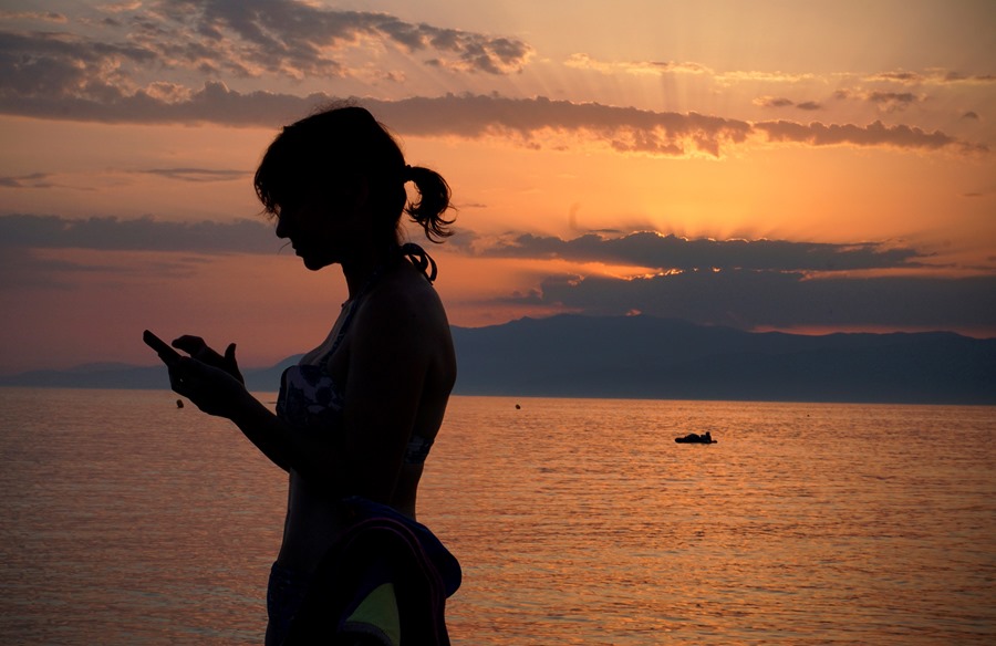Una mujer revisa su teléfono móvil en la playa de Cabo de Gata en Almería.