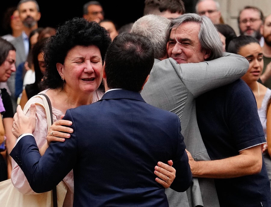 El presidente de la Generalitat, Pere Aragonés y el alcalde de Barcelona, Jaume Collboni (de espaldas), consuelan a familiares de la mujer asesinada ayer