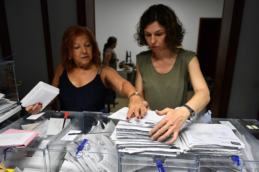 Trabajadoras de la junta electoral y representantes de partidos políticos inician el recuento de votos del exterior.