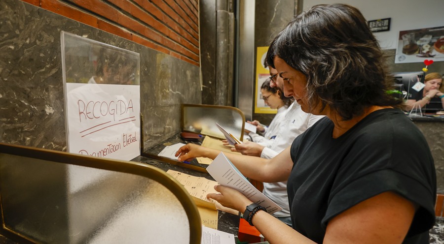 Tres ciudadanos realizan el voto por correo en una oficina de correos en Bilbao