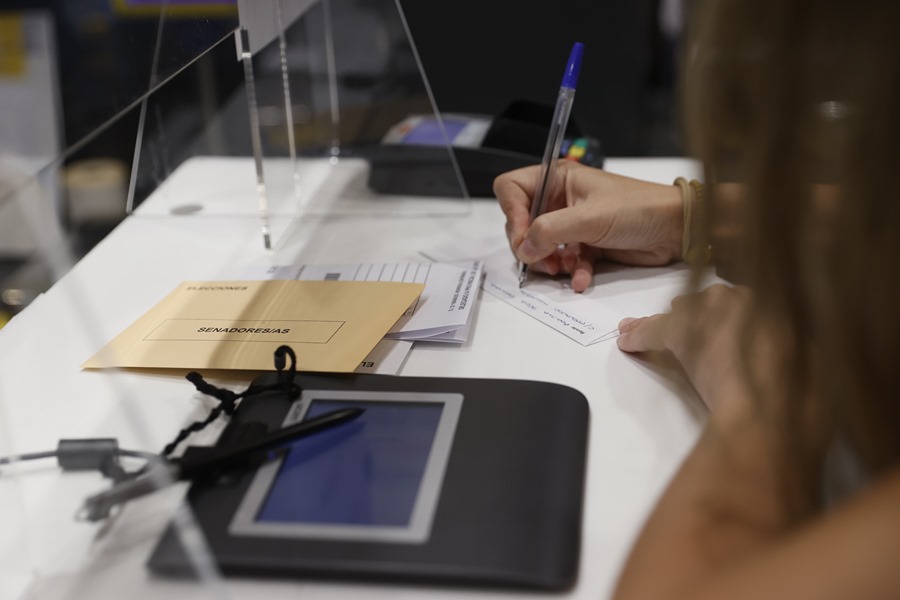Una mujer cumplimenta la documentación para ejercer el voto por correo en una oficina de Madrid.