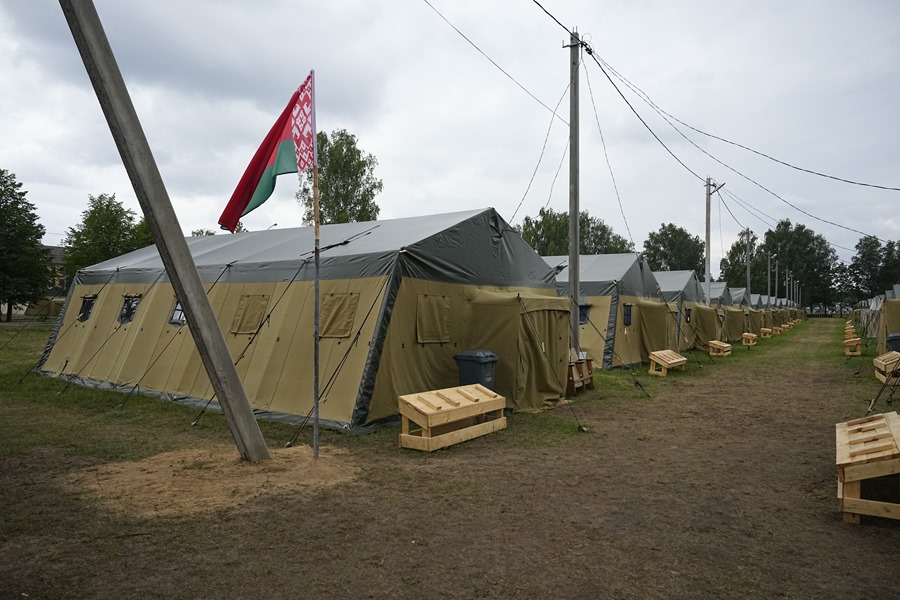 La bandera nacional de Bielorrusia ondea cerca de tiendas de campaña en un campamento del ejército bielorruso, que ah sido ofrecido a los soldados de Wagne